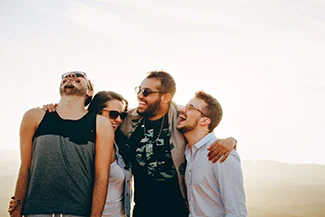 Four friends stand together on a hill, embodying the joy and mutual blessing of true friendship.