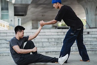 Two men train in martial arts on the steps, emphasizing the time and effort needed to cultivate lasting friendships.