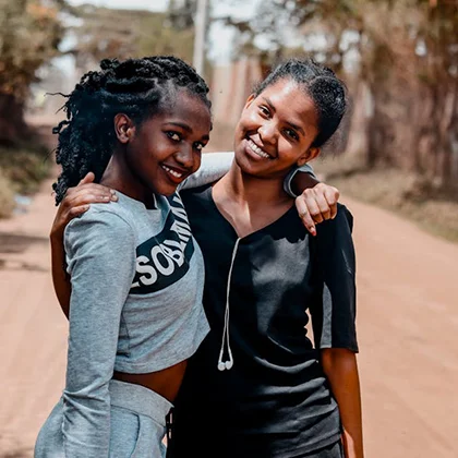 Two cheerful young women pose for a photo, embodying the joy and warmth of their friendship in a delightful moment.