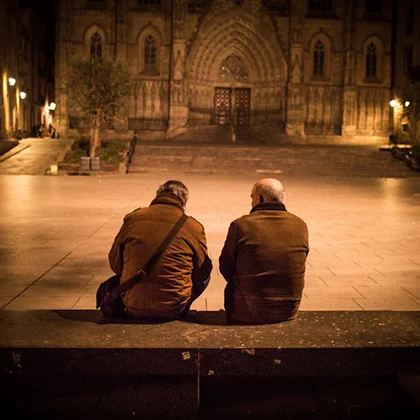 Two friends on a bench, illustrating the importance of support and companionship in fostering growth and progress.