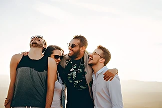 Four friends stand together on a hill, embodying the joy and mutual blessing of true friendship.