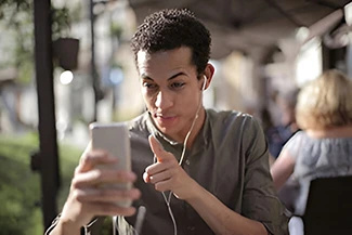 A man gazes at his cell phone, symbolizing the connection of true friends despite physical distance.