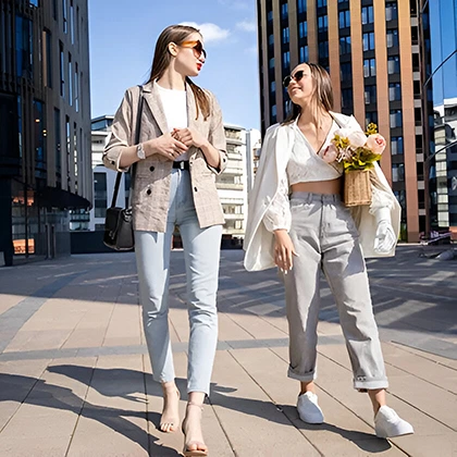 Two women stroll together down a bustling city street, embodying friendship and the joy of shared experiences.