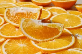 A vibrant display of orange slices neatly arranged on a wooden table, showcasing their bright color and fresh appeal.