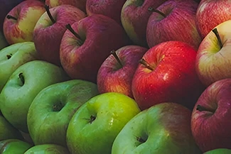 A vibrant pile of green and red apples stacked together, showcasing their fresh and appealing colors.