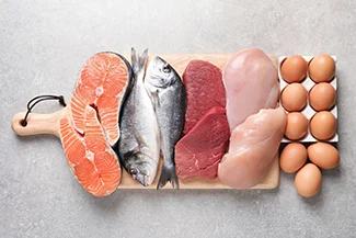 A cutting board displays fish, eggs, and lean meat, emphasizing heart-healthy food choices for a balanced diet.