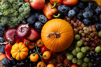 A colorful assortment of seasonal fruits and vegetables beautifully arranged on a table, showcasing freshness and flavor.