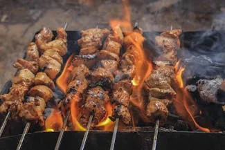 Juicy grilled chicken kebabs on the grill, exemplifying a healthier cooking technique compared to traditional frying methods.