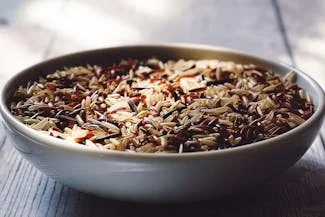 A bowl of brown rice on a wooden table, highlighting the nutritious benefits of whole grains rich in antioxidants.