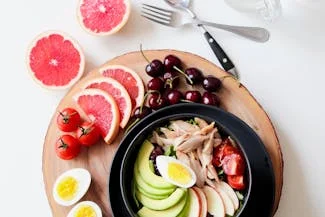 A colorful plate featuring a fresh salad, sliced eggs, and grapefruit, showcasing a nutritious mix of foods for optimal health.