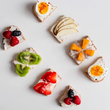 A colorful assortment of fruits and eggs served on toast, promoting healthier snack choices over chips or candy.