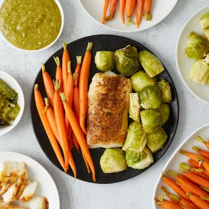 A colorful plate featuring chicken, carrots, and assorted vegetables, promoting a balanced diet rich in vitamins and minerals.