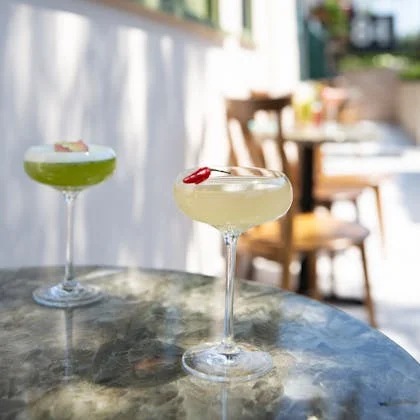 Two cocktails placed on an outdoor table, a delightful scene that underscores the importance of moderation in alcohol consumption.