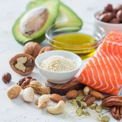 A selection of heart-friendly foods, featuring healthy fats like avocados and nuts, which can positively impact cholesterol levels.