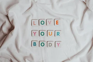 A white sheet displaying the phrase 'love your body', promoting body positivity and self-acceptance.