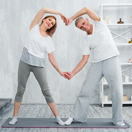 A senior couple performing yoga in a tranquil space, embodying gratitude for their physical abilities and wellness.