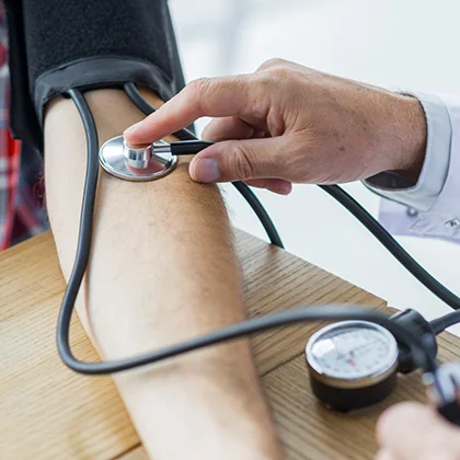 A doctor assesses a patient's blood pressure, reinforcing the idea that prevention is preferable to treatment.