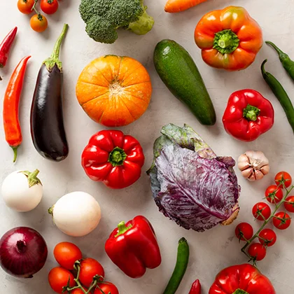 A diverse selection of vegetables arranged in a circular pattern on a white surface, showcasing their vibrant hues and health properties.