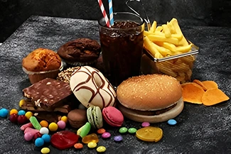 A table laden with various processed foods, highlighting unhealthy fats, sugars, and salts in the meal spread.