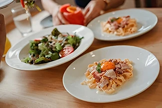 Two servings of balanced meals displayed on a wooden table, emphasizing the importance of portion control for health.