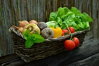 A rustic wooden table displays a basket overflowing with colorful vegetables, highlighting their role as nature's medicine