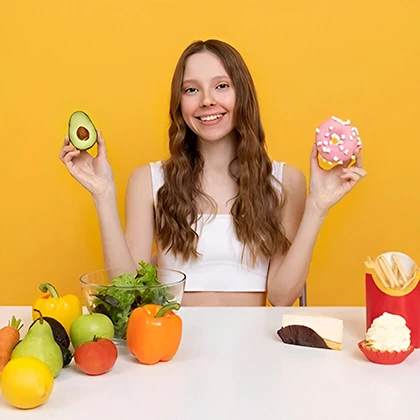 A woman presents two donuts and an avocado, illustrating the harmony of enjoying treats while prioritizing health.