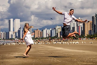A man and woman leaping together, capturing the essence of joy and the vibrant energy of a new day.