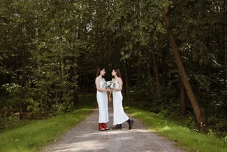  In a serene forest, two women in white dresses stand on a path, symbolizing the importance of keeping promises and commitments.