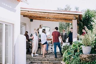 People gather outside a house with a patio, highlighting the value of mutual respect among family and friends.