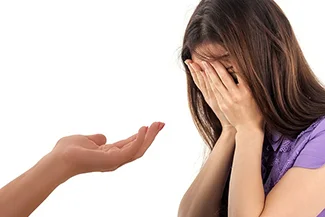 A woman cries, her hands covering her face, symbolizing the importance of supporting one another through life's challenges.