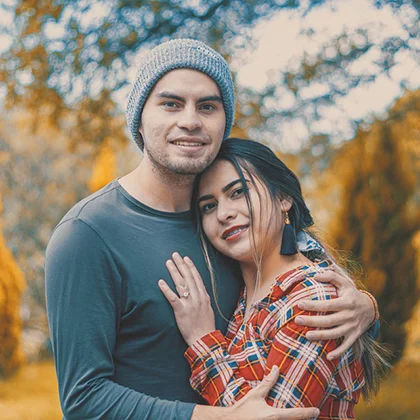 A man and woman embrace in a field, symbolizing true love and acceptance of one another's authentic selves.