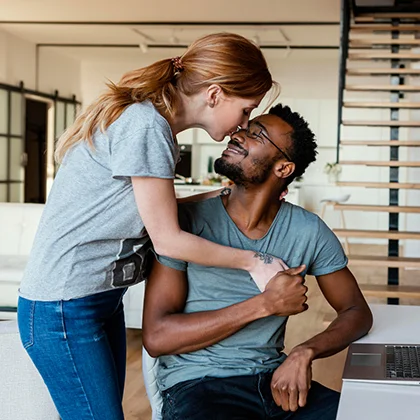 A man and woman, both smiling, exemplify teamwork and camaraderie through their joint activity.