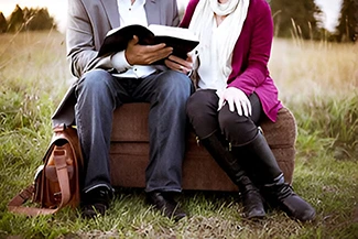 A couple reads a book on a couch, emphasizing the importance of relationship check-ins and shared moments.