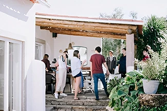 People gather outside a house with a patio, highlighting the value of mutual respect among family and friends.