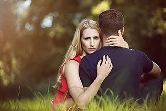 A man and woman enjoy a moment on the grass, embodying the essence of forgiveness and the understanding of imperfection.