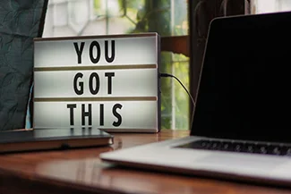 A motivational sign on a desk reads, 'You got this,' encouraging self-trust and inner strength.