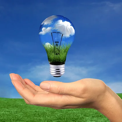 A person holds a light bulb containing grass and clouds, symbolizing creativity and the potential for new ideas each day.