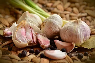 A selection of garlic and diverse herbs presented on a table, emphasizing their freshness and culinary potential.