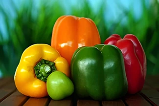 A collection of bright, colorful peppers displayed on a wooden table, highlighting their diverse shapes and vivid colors.