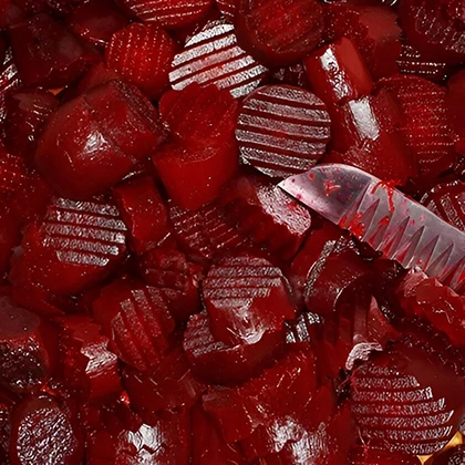 A knife rests centrally atop a vibrant pile of freshly harvested red beets, showcasing their rich color and texture