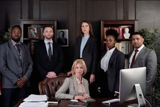 A diverse group of business professionals, including many women in leadership roles, poses confidently for a photo.