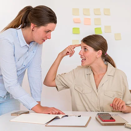 A woman wearing a blue shirt, reflecting her meticulous nature and attention to detail, stands with poise and confidence.