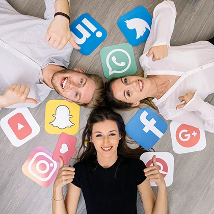 Three women lying on the floor, surrounded by social media icons, symbolizing strong professional and social networks.