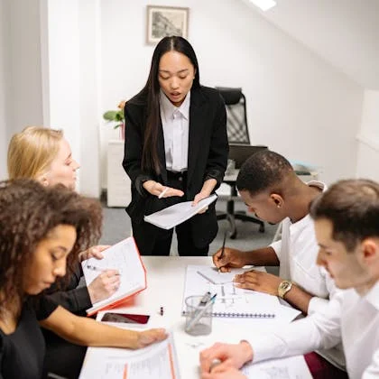 A professional woman in a business suit addresses a group, symbolizing the vital contribution of women to the global workforce.