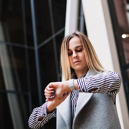 A woman wearing a vest exemplifies efficient time management skills, showcasing her organizational abilities.