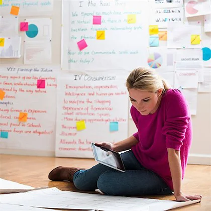 A woman sitting on the floor with a tablet, demonstrating her ability to tackle challenges with innovative solutions.